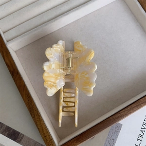 Detailed macro view of the marble texture resin butterfly hair claw in a wooden display box