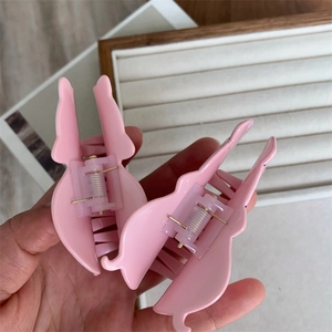 Detail of pink butterfly hair claws made of acrylic resin with golden metal springs