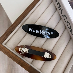 Barrettes à cheveux ovales géométriques en noir et écaille avec inscription New York