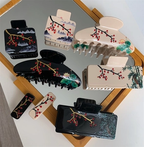 Détail des pinces à cheveux en acétate avec peinture à l'encre traditionnelle et strass rouges