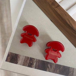 Gros plan détaillé d'une pince à cheveux rouge brillante avec logo Sanshine