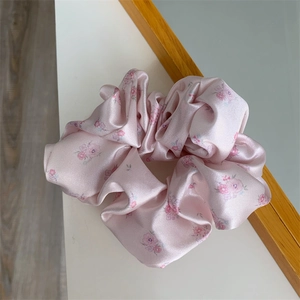 Pink and purple floral scrunchie with silky satin texture for delicate hair styling