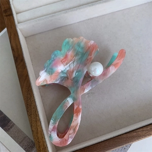 Detail of ginkgo leaf hair claw clip with pink and green acetate texture and pearl