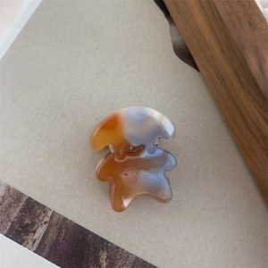 Détail de la pince à cheveux ours avec texture agate ambre et bleue et ressort métallique