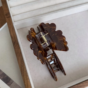 Detailed macro view of a tortoiseshell butterfly hair claw clip with a strong metal spring