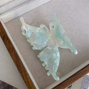 Détail de la pince à cheveux papillon 3D avec texture marbrée en acétate menthe
