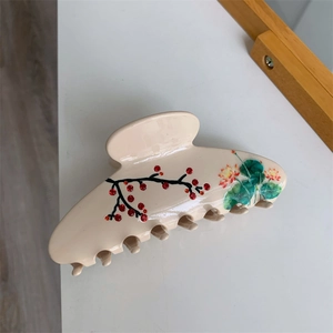 Détail d'une pince à cheveux beige avec des motifs chinois de lotus et de prunier