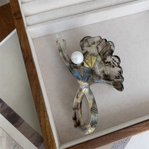 Detail of ginkgo leaf hair claw with marble texture and elegant pearl decoration
