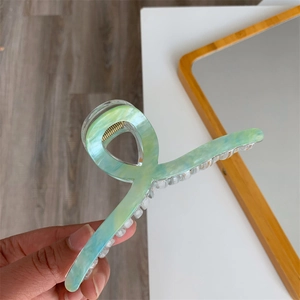 Detailed view of a 13cm light green marbled acetate hair claw clip with golden spring