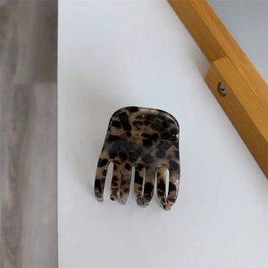 Classic tortoiseshell acetate hair claw clip for women on a clean white surface