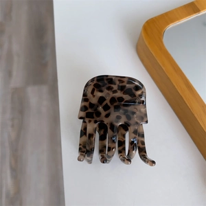 Close-up of tortoise shell leopard print acetate hair claw clip with glossy finish