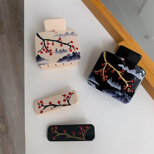 Détail de pinces à cheveux en acétate avec art du paysage chinois et strass rouges
