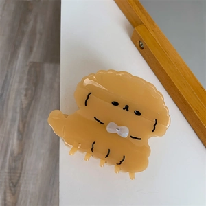 Detailweergave van abrikooskleurige hond haarclip met witte strik en een strassteen