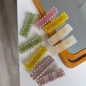 Lot de barrettes rectangulaires colorées avec perles sur un miroir de courtoisie en bois