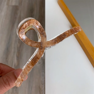 Close-up of a 13cm amber marble acrylic hair claw clip for thick hair with ribbon design