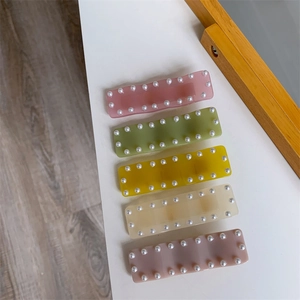 Détail d'un lot de 5 barrettes à cheveux carrées avec perles en diverses couleurs mates