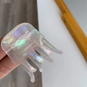 Detailed macro view of an acetate shark hair clip with pearlescent rainbow finish