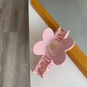 Detail of pink butterfly hair claw clip with cutout patterns and gold spring mechanism