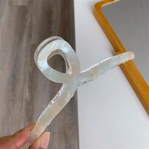 Detail of 13cm double-layered acrylic hair claw with blue marble pattern and gold spring