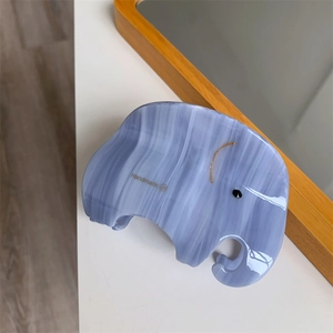 Detail of light blue marble textured elephant hair claw clip with handmade marking