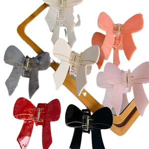 Bow-shaped acetate hair claw clips in various colors with elegant gold-rimmed edges