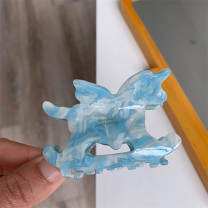 Détail de la pince à cheveux en acétate marbré bleu et blanc avec texte doré Barrette La France