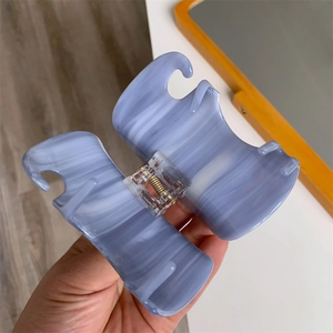 Close-up of lilac marble acetate hair claw clip showing spring detail and texture