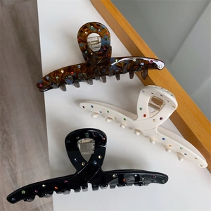 Trois pinces à cheveux en acétate avec strass colorés en écaille, blanc et noir
