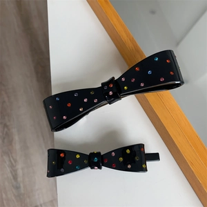 Elegant black bow hair clip set with colorful rhinestones on a polished acetate base