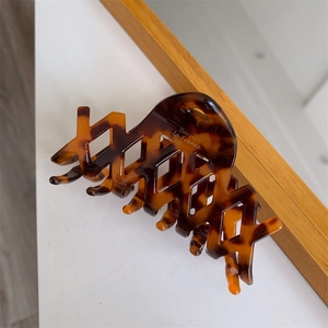 Dettaglio della pinza per capelli geometrica in acetato con motivo tartarugato e incisione