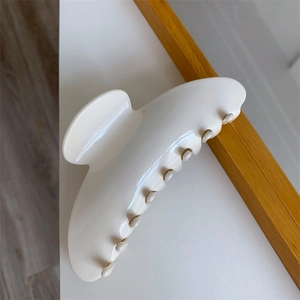 Macro view of creamy large acetate hair claw clip with smooth glossy finish and sturdy teeth