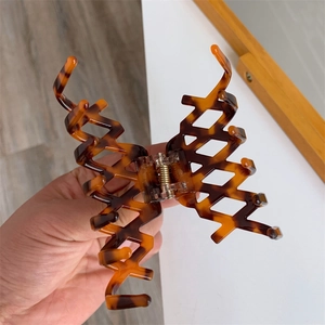 Dettaglio della grande pinza per capelli in acetato con motivo tartarugato e vuoti