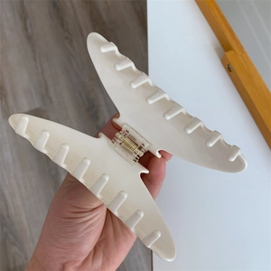 Detail shot of a large cream acetate claw clip with a durable metal spring mechanism