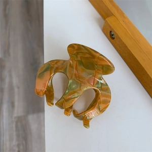 Detail der kürbisförmigen Haarklammer aus Acetat mit Marmormuster und goldenem Glitzer