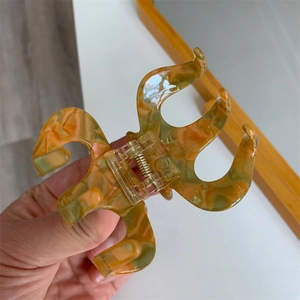 Detailansicht der polierten orangefarbenen Haarspange mit Marmortextur