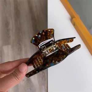 Détail de la pince à cheveux en acétate avec strass colorés et motif en écaille de tortue