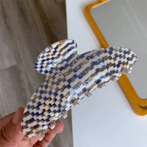Detail showing high-quality thick acetate hair claw with blue checkerboard texture