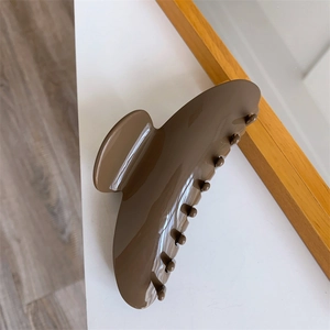 Macro detail of large dark brown tortoiseshell hair claw clip with glossy finish