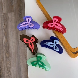 Cinq pinces à cheveux à nœud en acétate coloré en violet, rouge, marron, bleu et vert