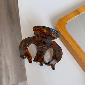 Detailansicht der Haarspange in Schildpatt-Optik mit goldener Aufschrift im Retro-Stil