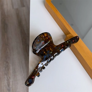 Détail d'une grande pince à cheveux écaille de tortue avec strass colorés et finition en acétate
