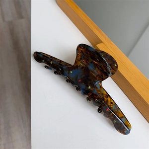 Détail d'une grande pince à cheveux en acétate avec motif écaille et strass colorés