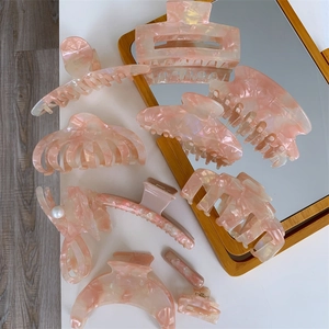 Detailed collection of pink acetate hair claws and clips with marble texture finish