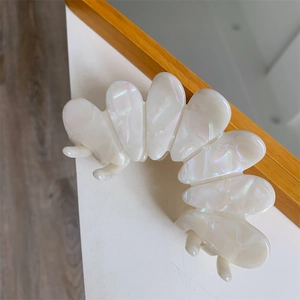 Macro detail of the iridescent pearl white acetate hair claw clip with shell texture