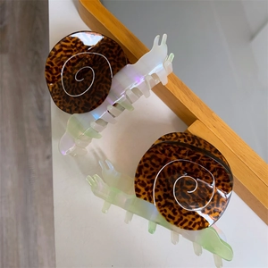 Creative snail shaped acetate hair claw clips with tortoiseshell pattern on white surface