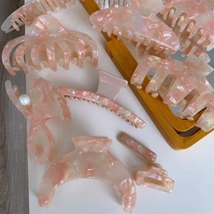 Detailed collection of pink marble acetate hair claws and clips with pearl accents
