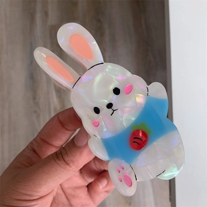 Detail of cute bunny acetate hair claw clip with pearlescent white finish and carrot motif
