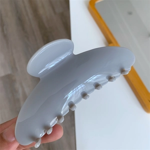 Detail of large grey acetate hair claw clip with glossy finish and strong grip design