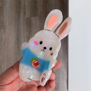 Macro detail of cute acetate rabbit hair claw with pearlescent finish and carrot motif