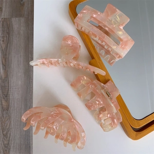 Detail view of pink marble acetate hair claw set featuring large rectangular and arc clips